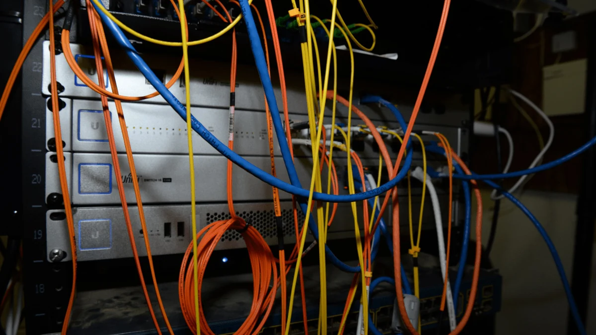 Server rack with multiple networking devices and colorful patch cables — representative of a multi-building resort audio backbone